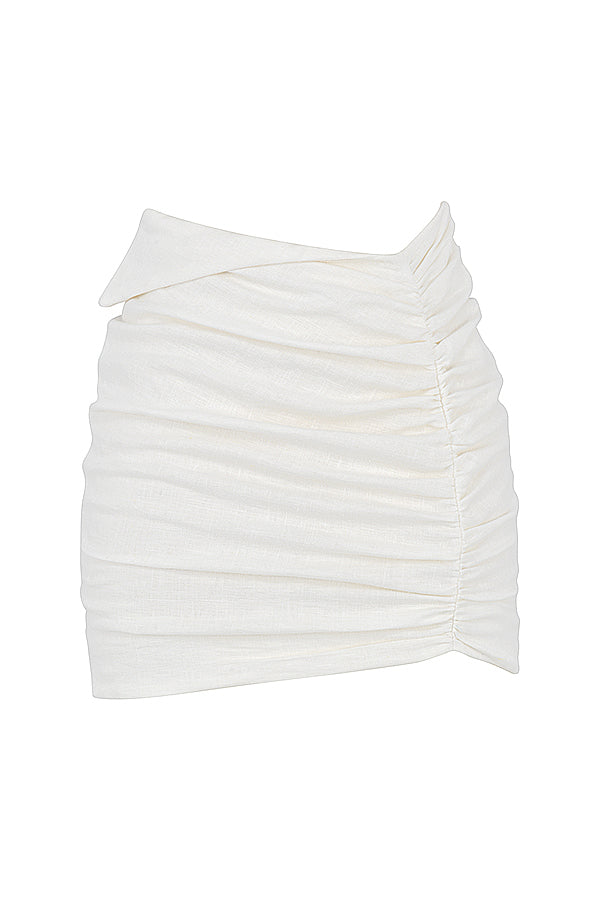 Blouse cropped blanche cassée élégante associée à une mini-jupe taille haute tendance.