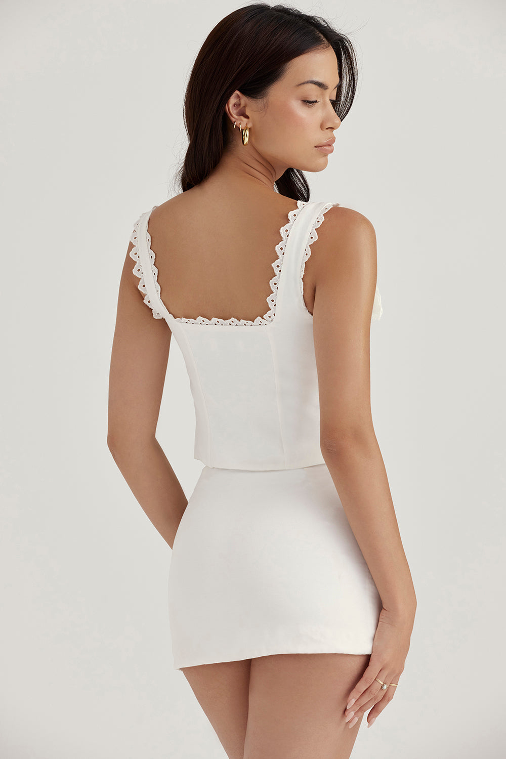 Top court en dentelle blanche chic avec un nœud élégant et une mini-jupe A-ligne en lin stylée.